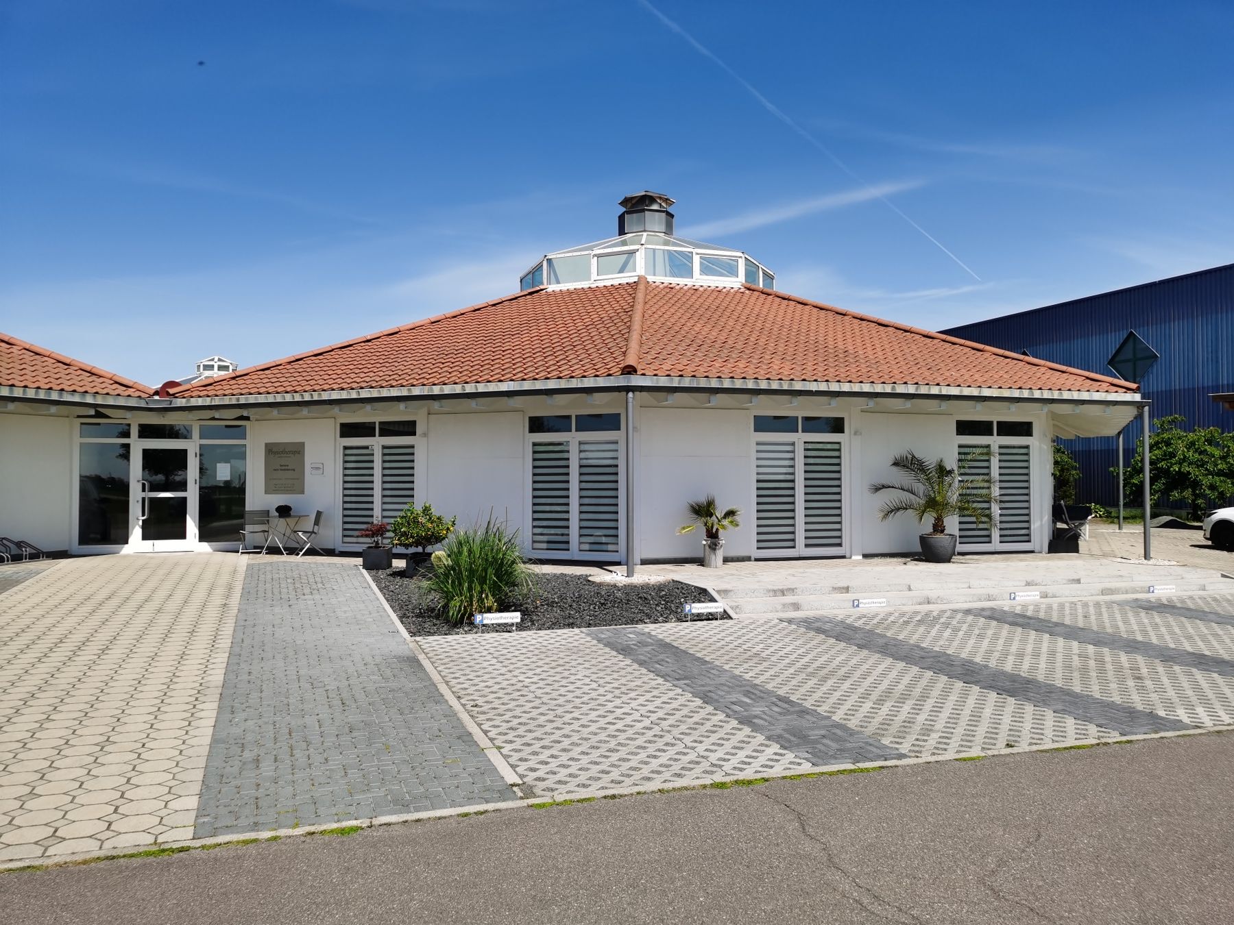 Das Praxisgebäude der Physiotherapie Isabell Schirmer mit Parkplätzen davor